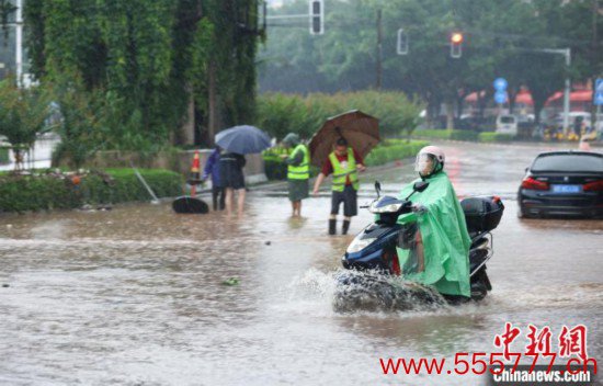 5月10日近期国内新闻热点事件，广西沿海遭遇强降雨。图为钦州市民众在积涝中出行。陆敏  摄